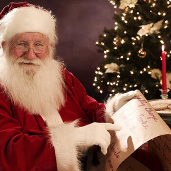 santa pointing to his nice list and writing letters